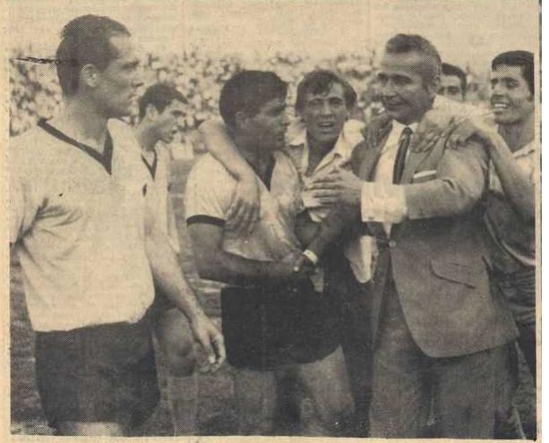 Περιστοιχισμένος απο οπαδούς της ομάδας και ενώ συγχαίρει τον Βασιλείου μετα το τέλος του αγώνα ΑΕΚ-Ηρακλή 2-0 με τον οποίο ολοκληρώθηκε το πρωτάθλημα και η ΑΕΚ στέφθηκε πρωταθλήτρια Ελλάδας.